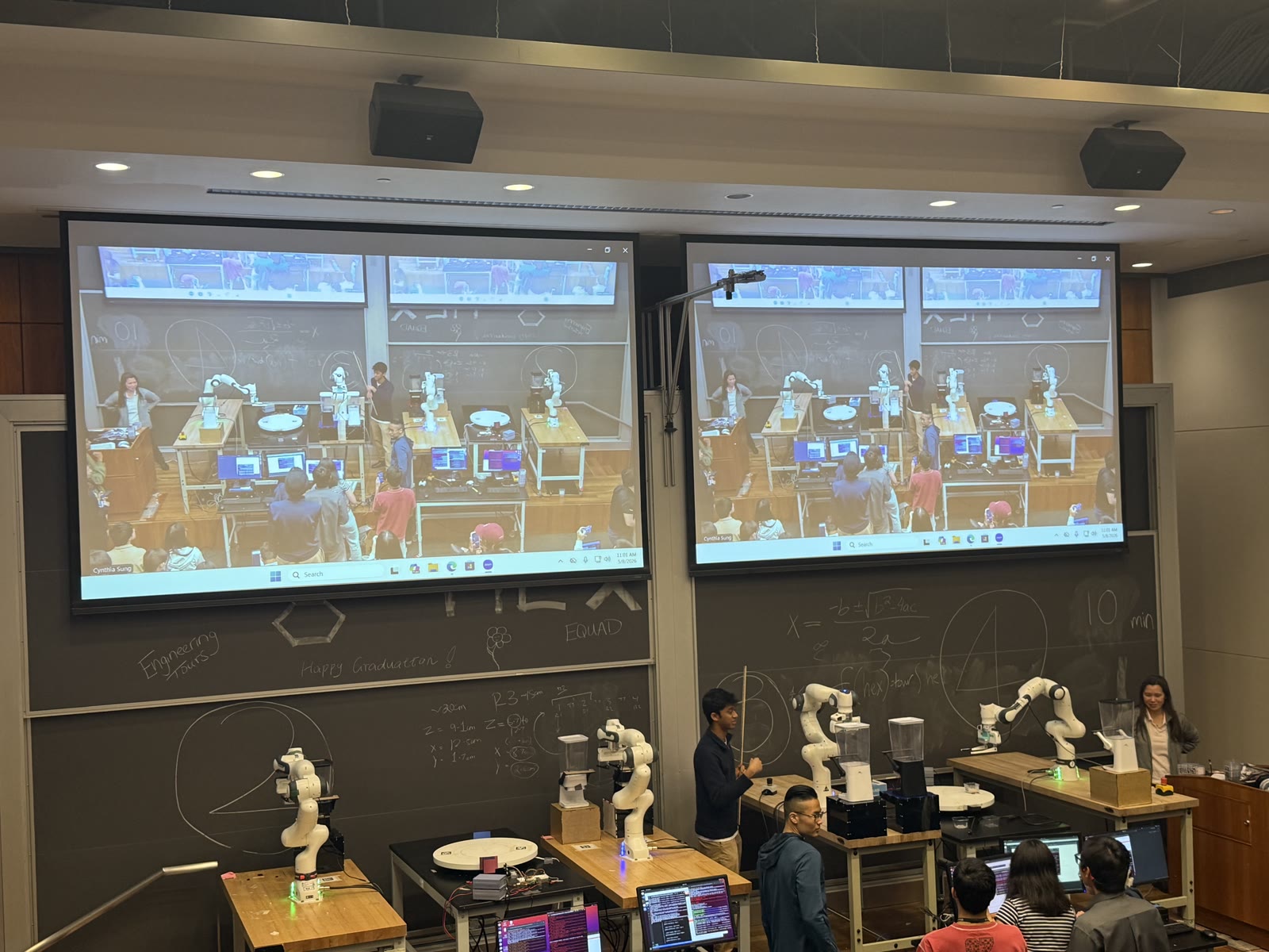 Four robot arms arranged across two trail mix assembly lines during the classroom demonstration